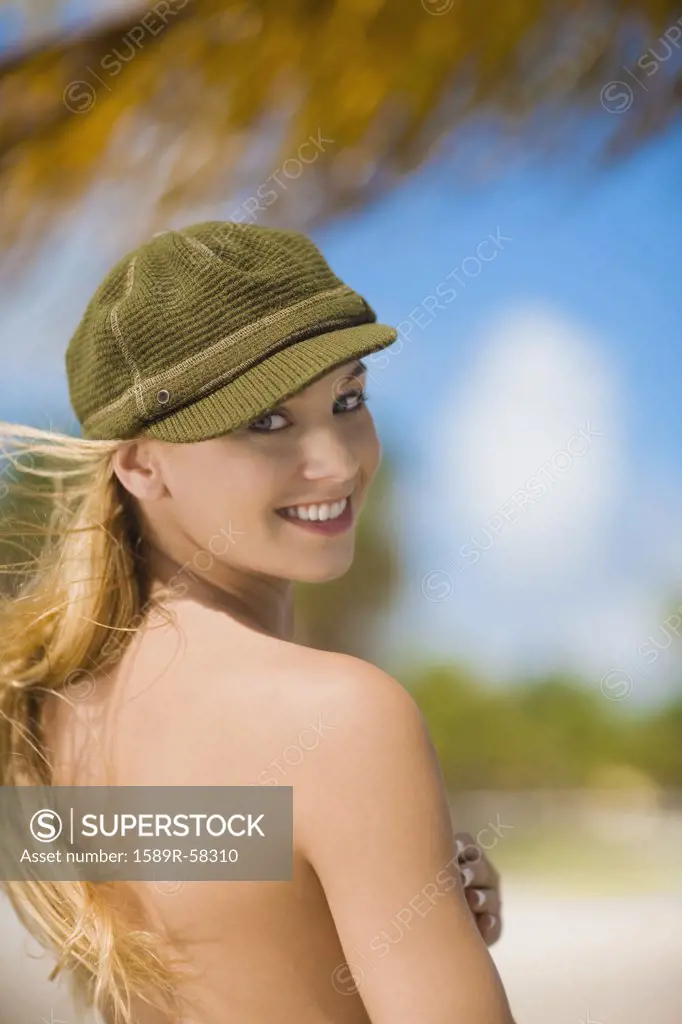 Topless Hispanic woman looking over shoulder