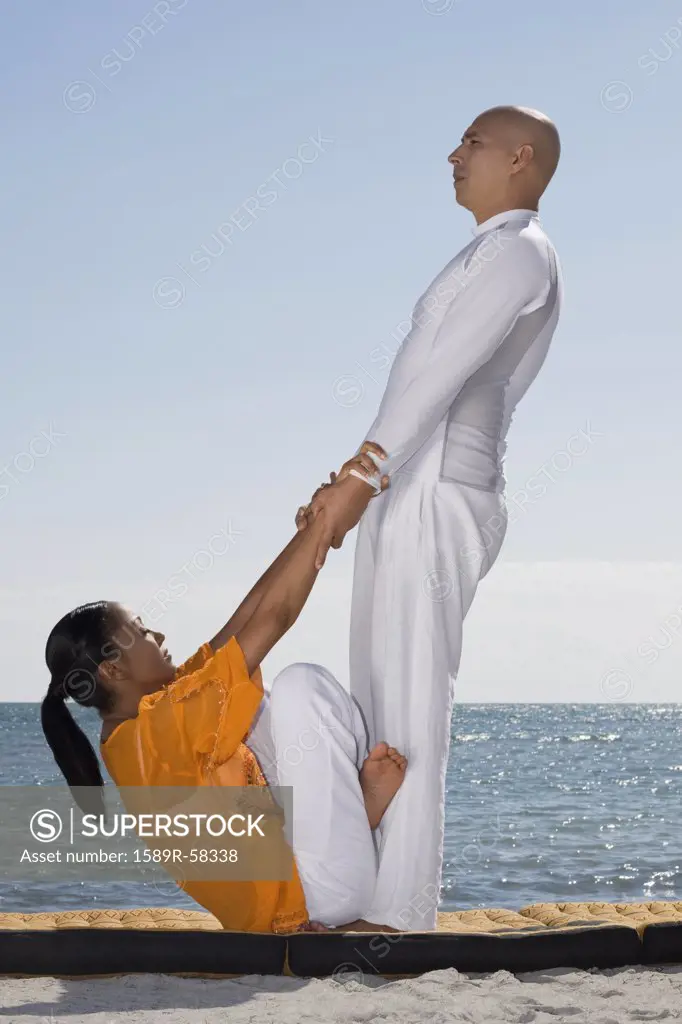 Hispanic couple practicing yoga