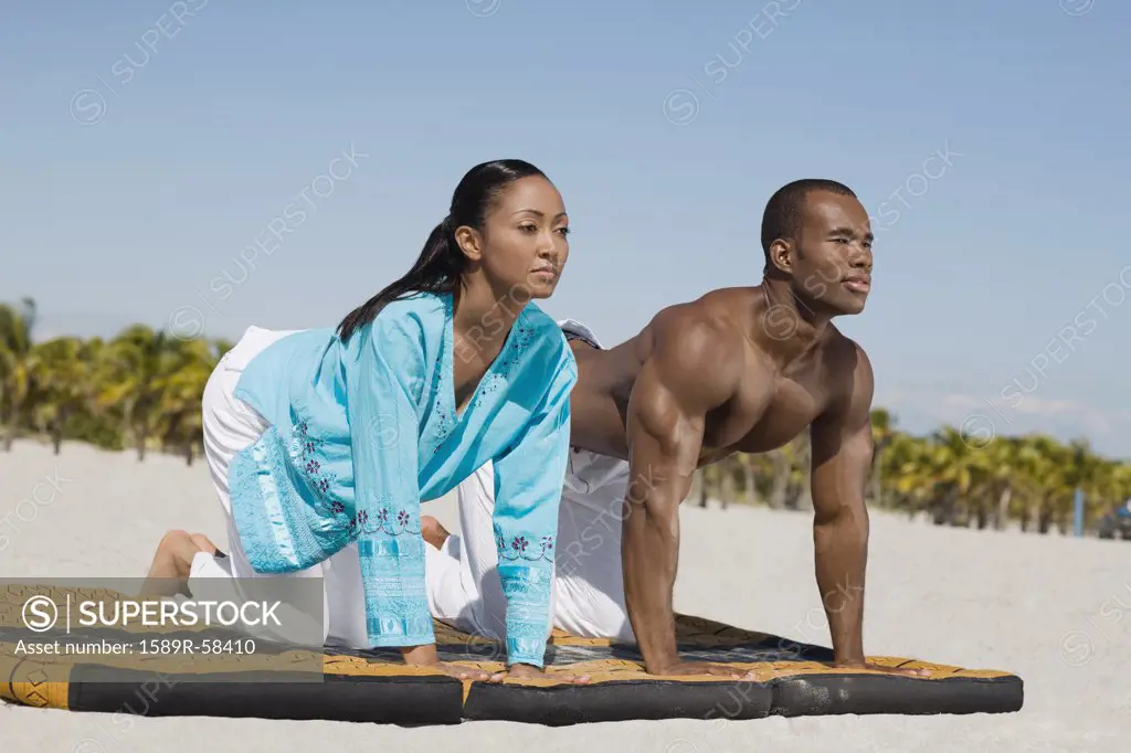 Multi-ethnic couple practicing yoga