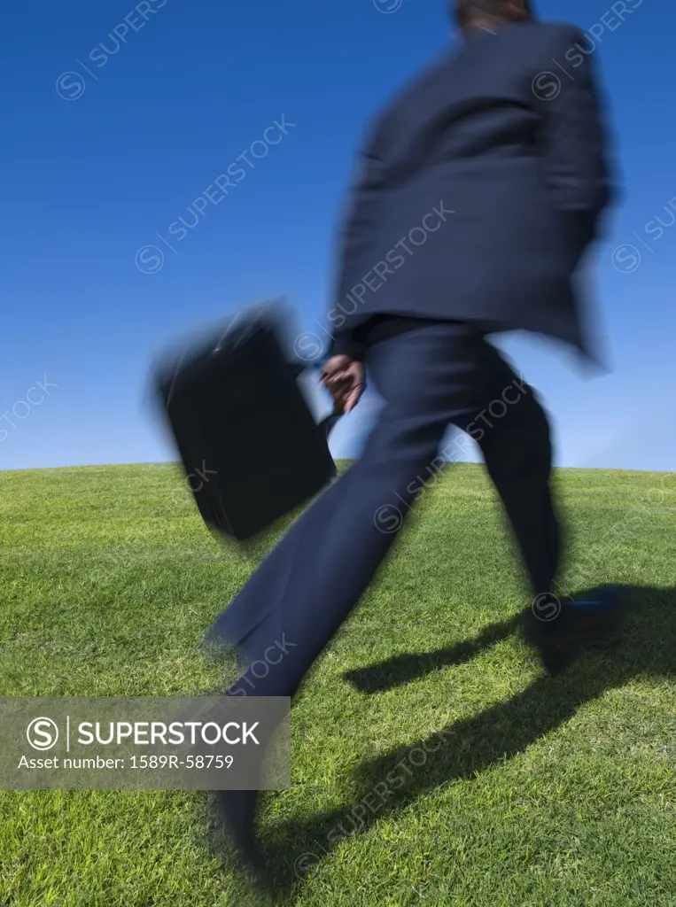 African businessman running uphill