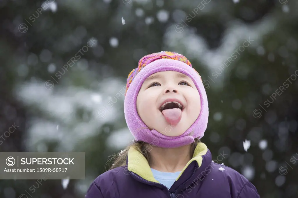 Asian girl sticking out tongue in snow