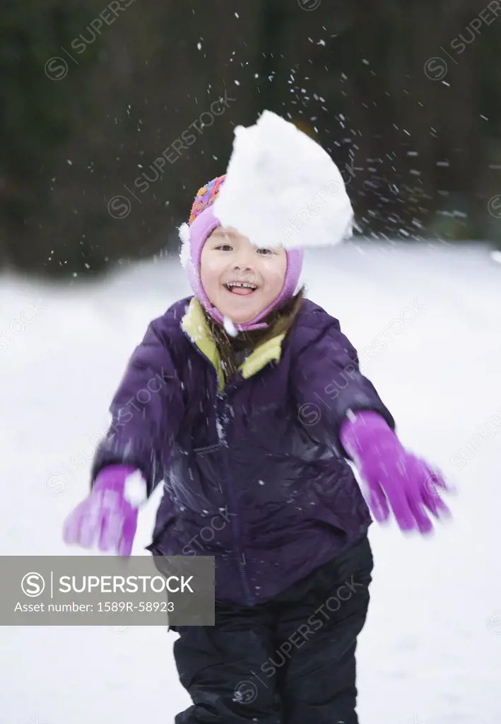 Asian girl throwing snowball