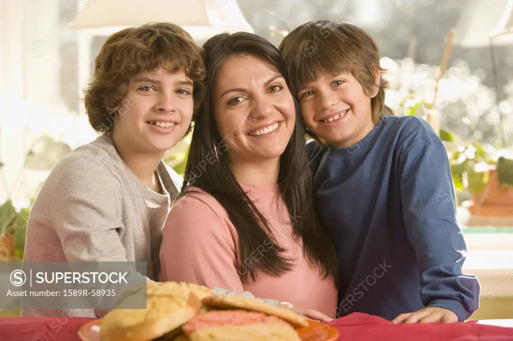 Hispanic mother and sons next to plate of cookies