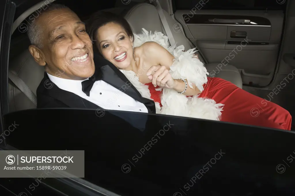 Senior African couple hugging in limousine