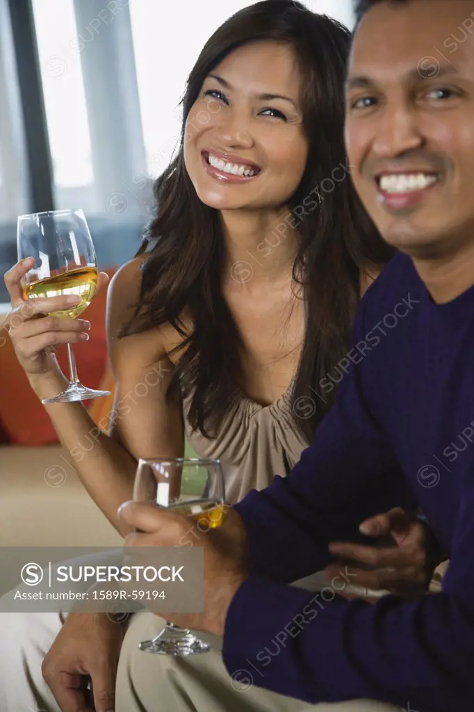 Multi-ethnic couple drinking wine