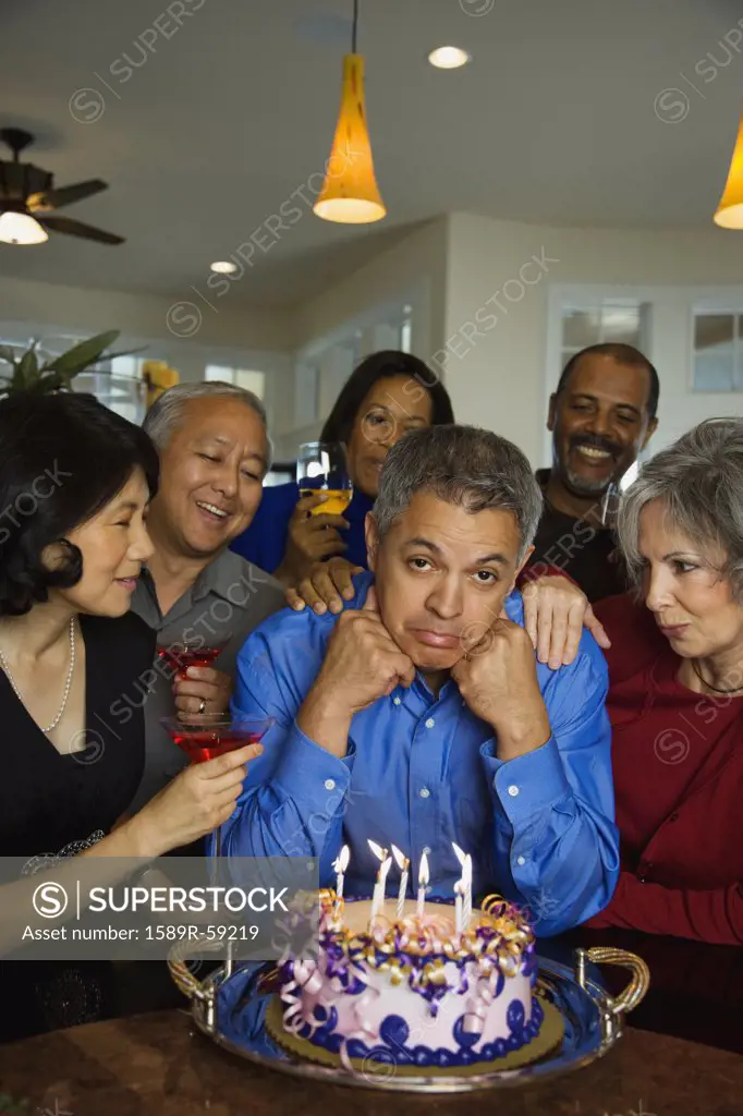 Hispanic man celebrating birthday with multi-ethnic friends