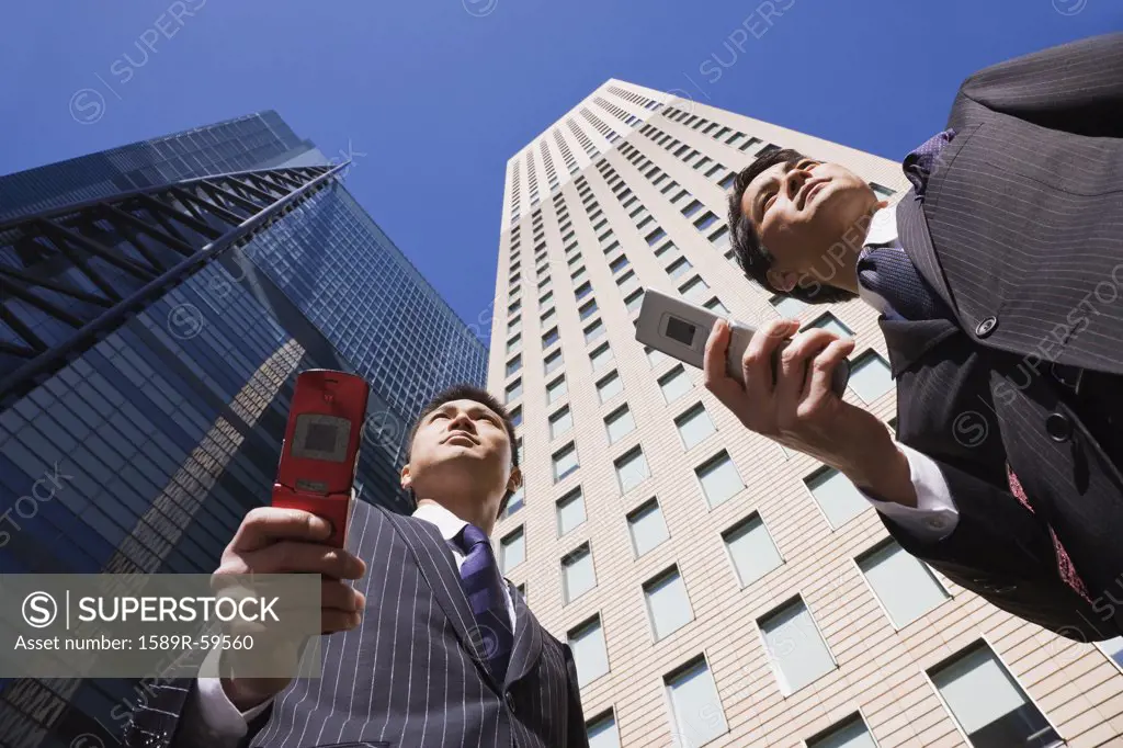 Asian businessmen holding cell phones