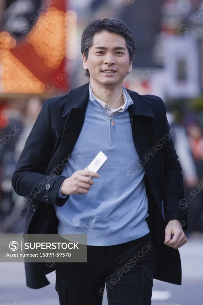 Asian man running with cell phone