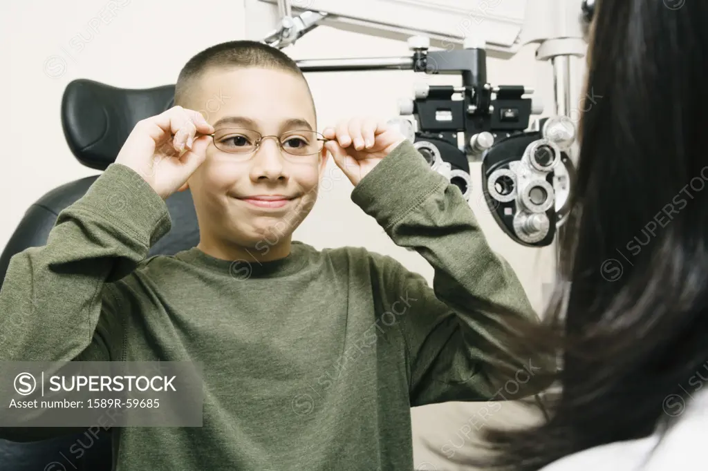 Asian boy trying on eyeglasses