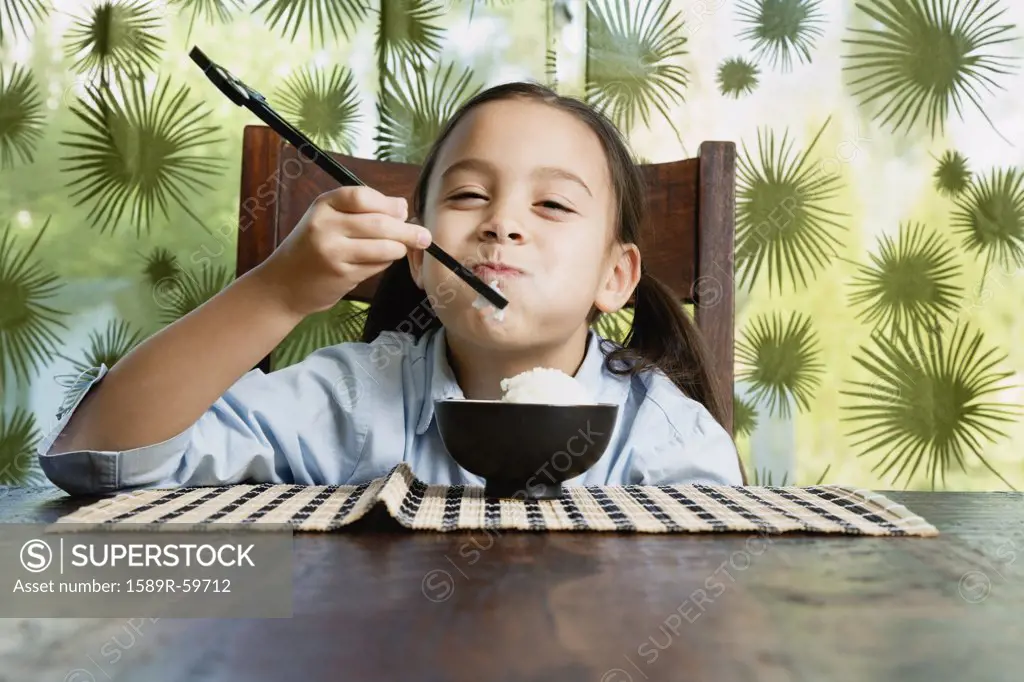 Asian girl eating bowl of rice