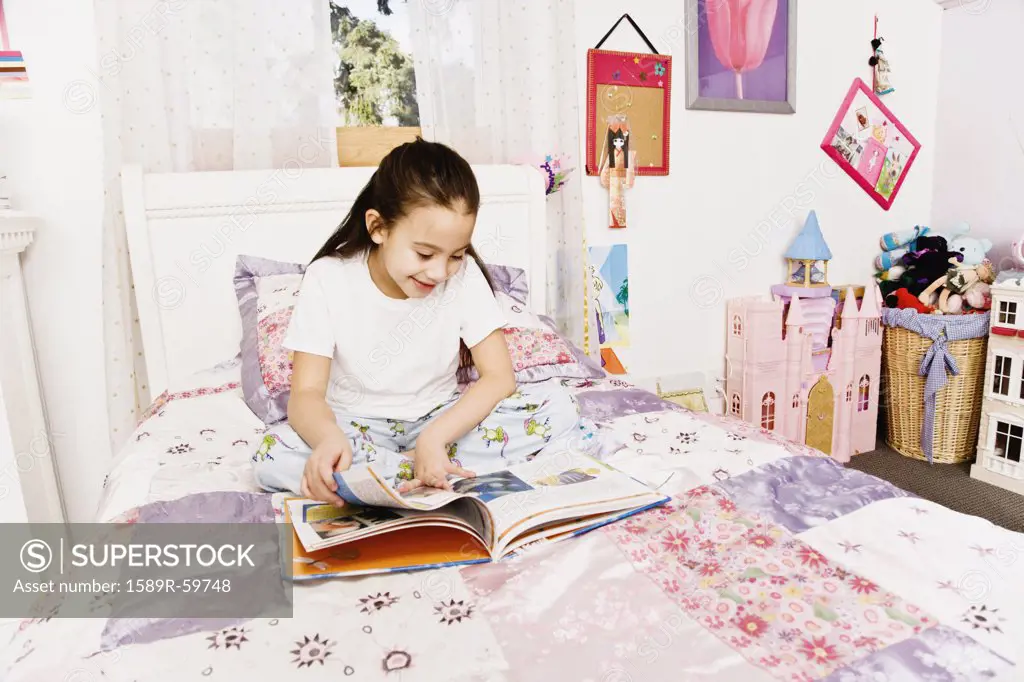 Asian girl reading on bed