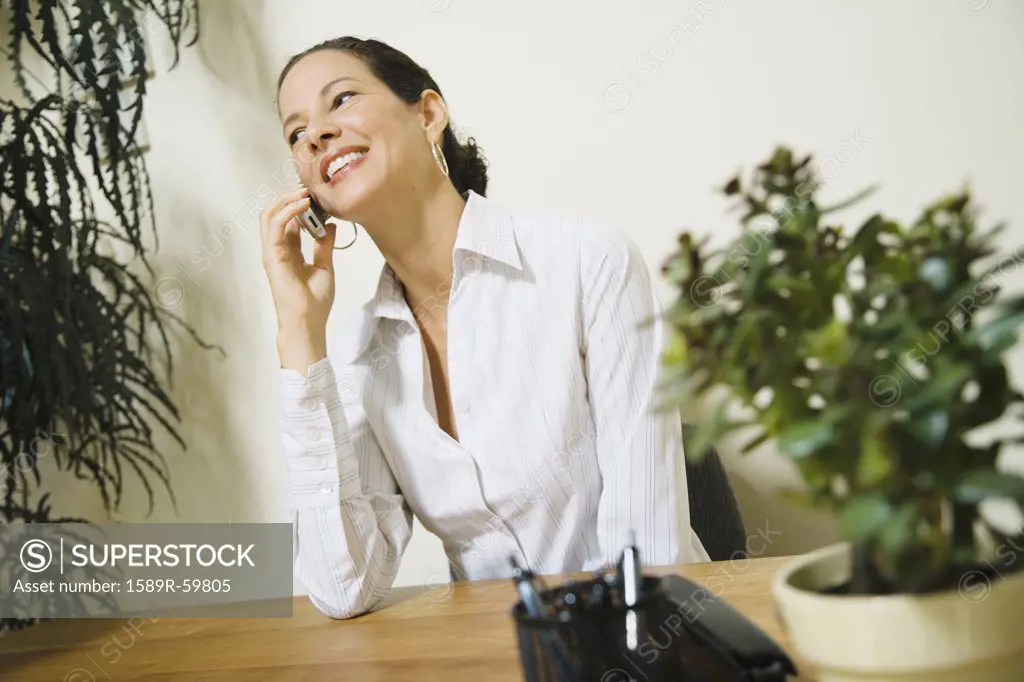 Mixed Race businesswoman talking on cell phone