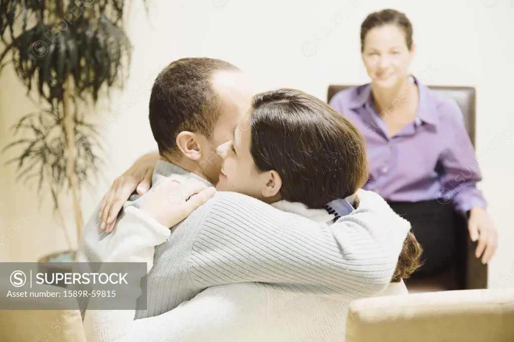 Multi-ethnic couple hugging at therapy session