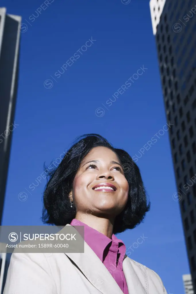 African businesswoman looking up