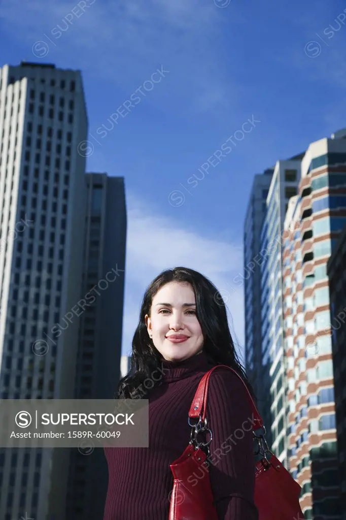Hispanic woman in front of high-rises