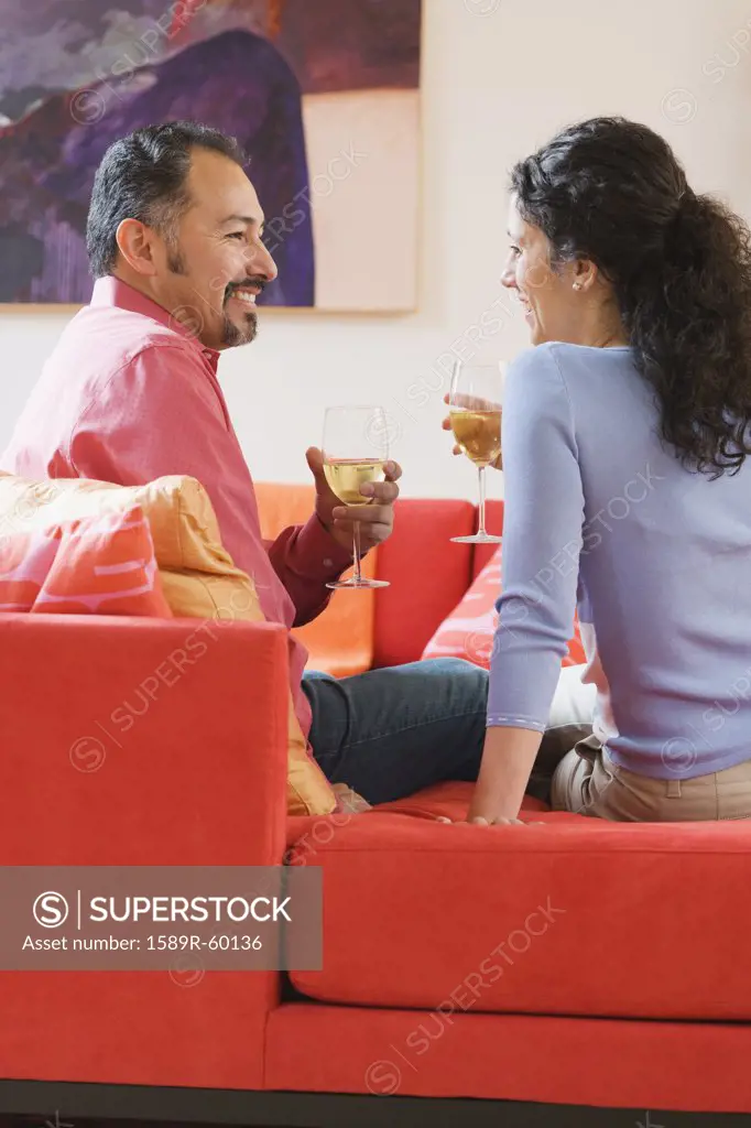 Hispanic couple drinking wine