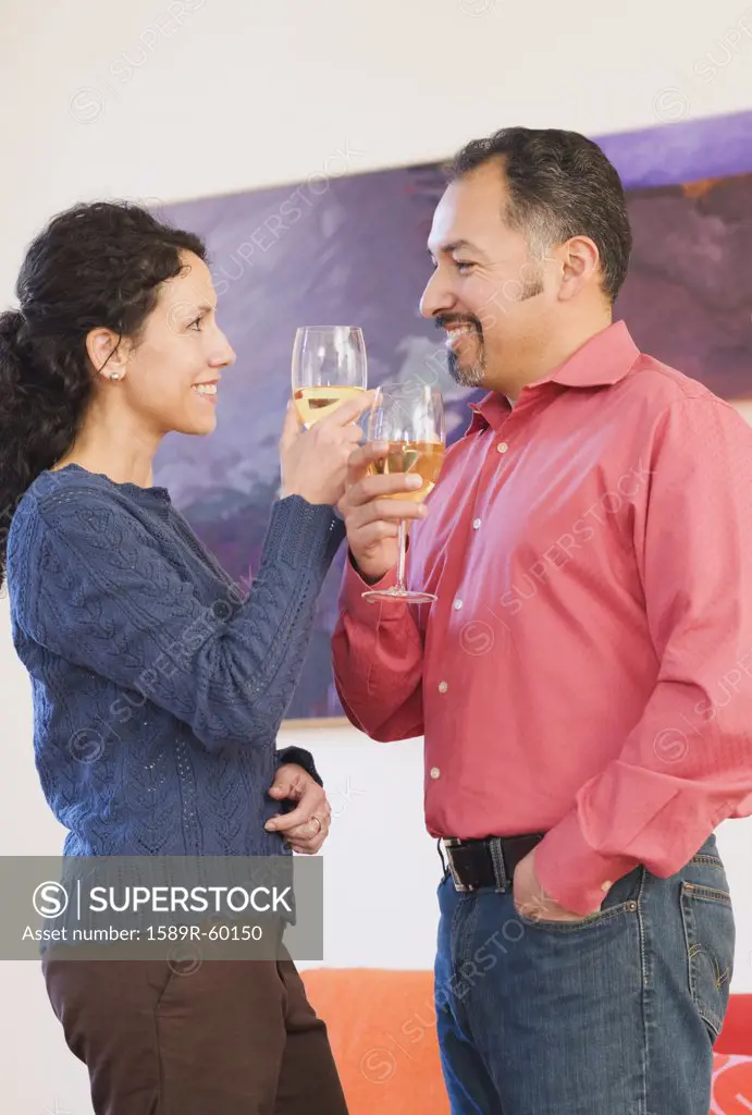 Hispanic couple toasting with wine