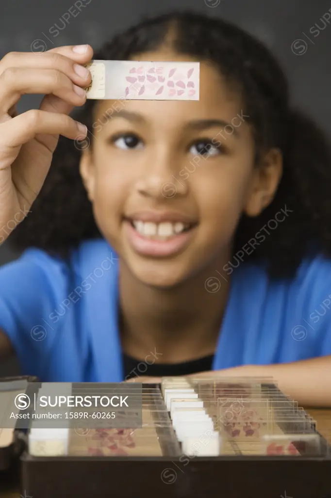 Mixed Race girl looking at microscope slide