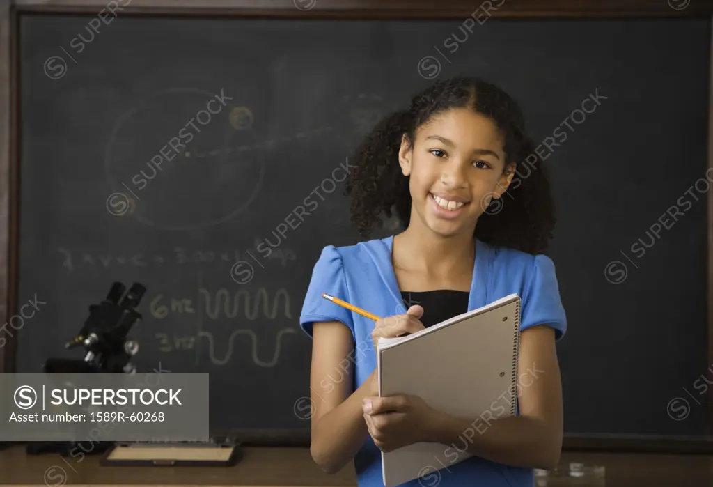 Mixed Race girl writing on notebook