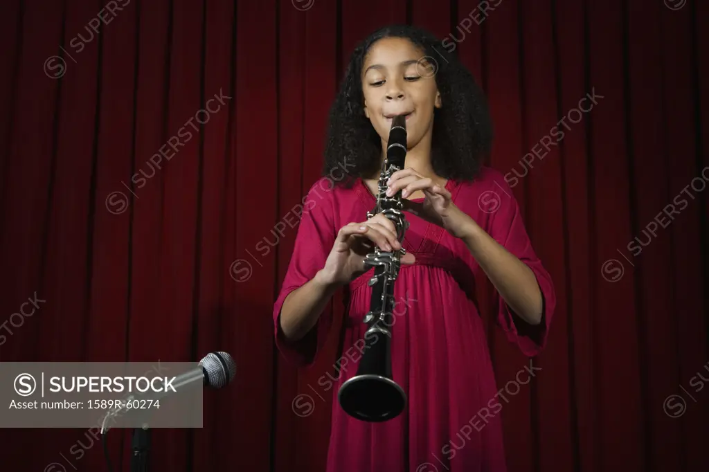 Mixed Race girl playing clarinet on stage