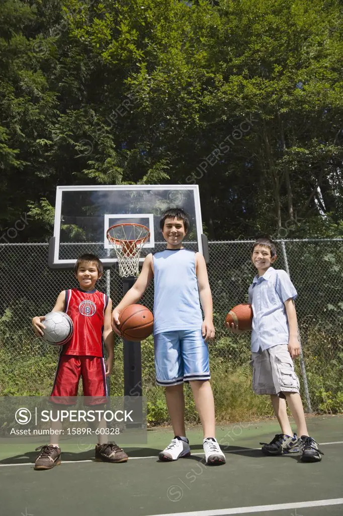 Asian brothers holding basketballs