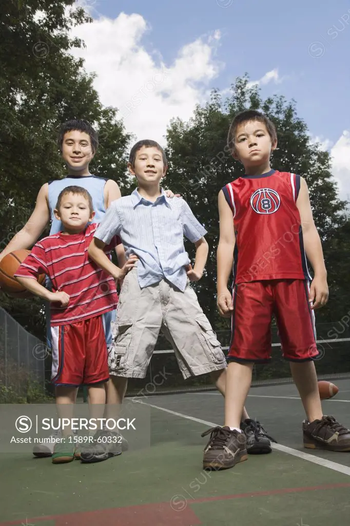 Asian brothers standing on basketball court