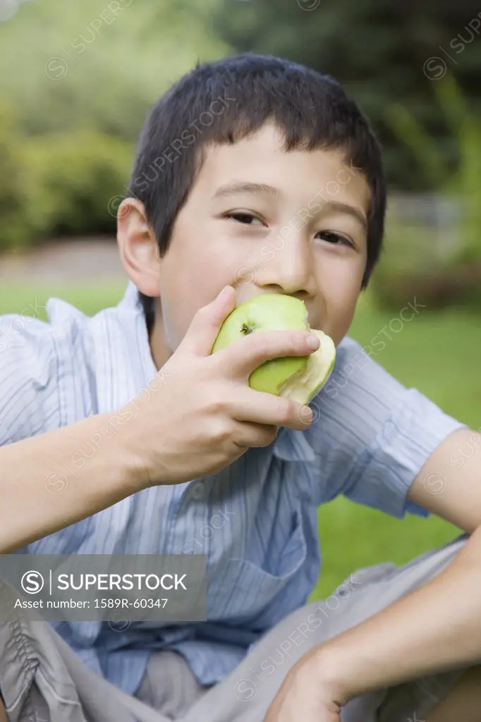 Asian boy eating apple