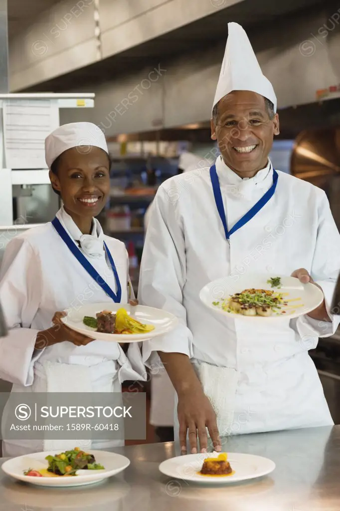 African chefs holding plates of food