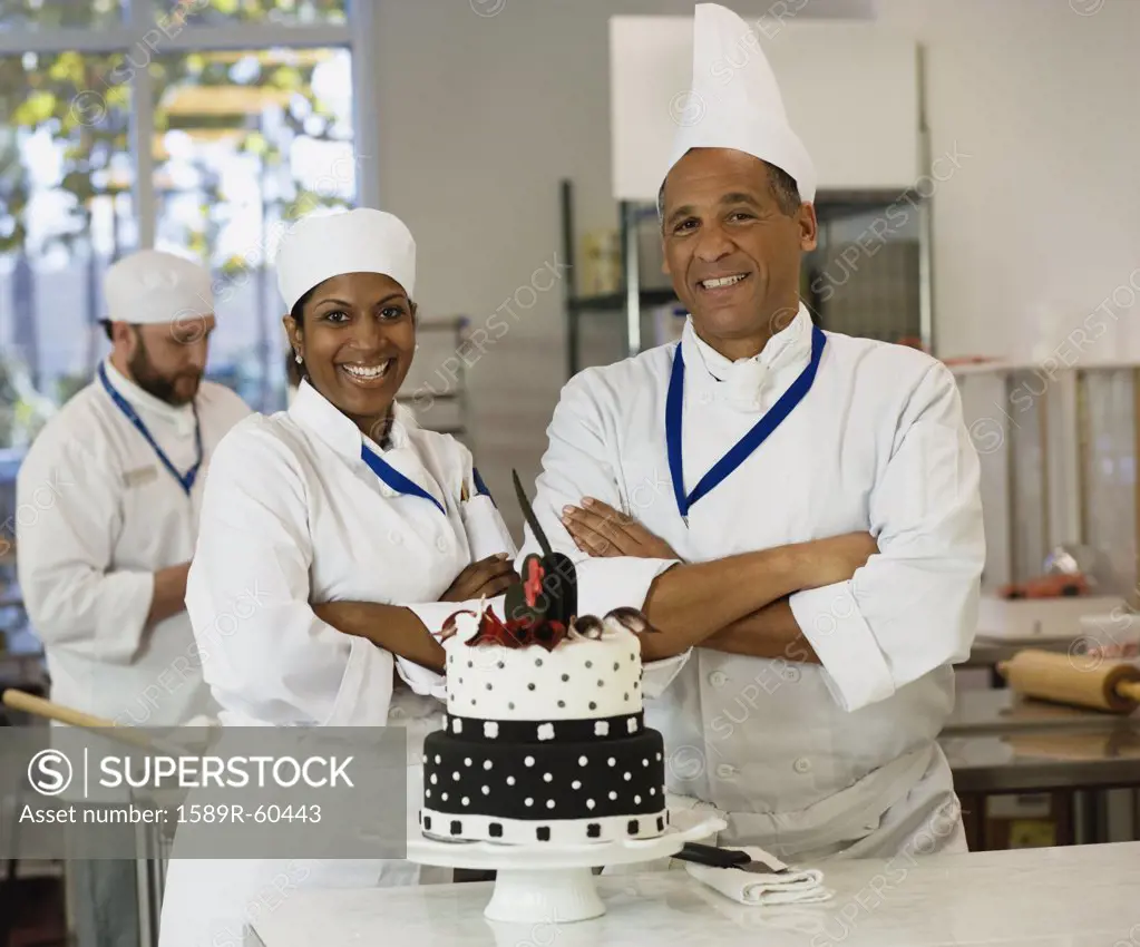 Multi-ethnic pastry chefs next to cake