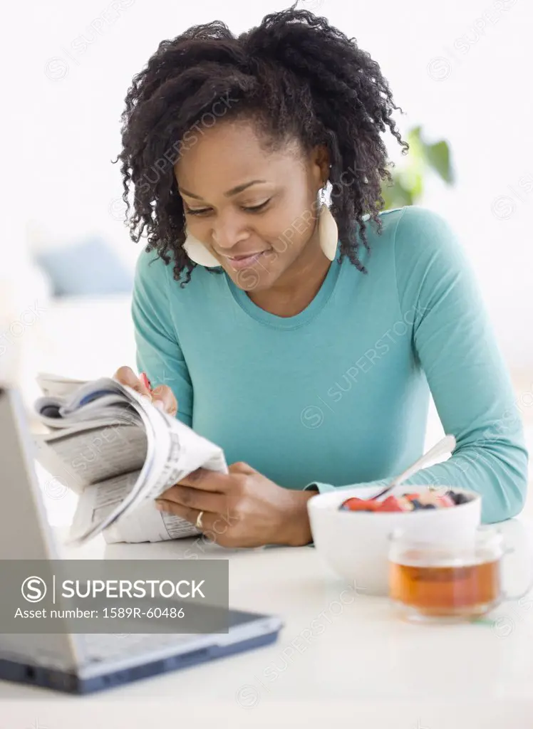 African woman reading newspaper
