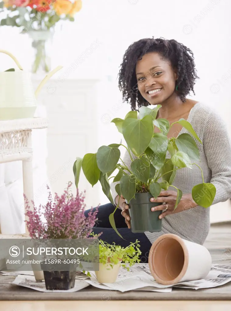 African woman holding potted plant