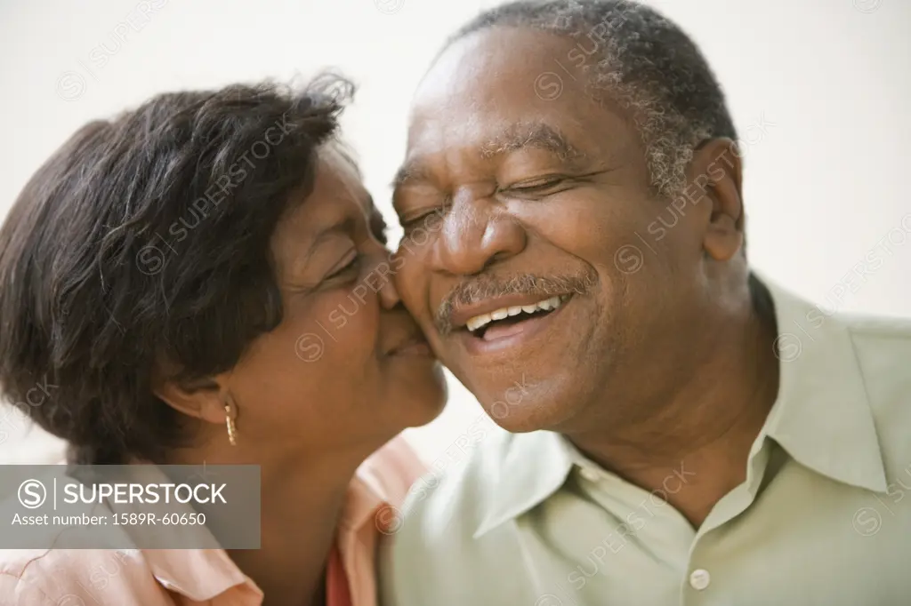 Senior African woman kissing husbands cheek 