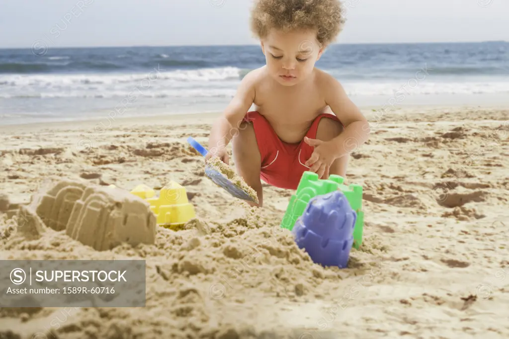 Mixed Race baby playing at beach