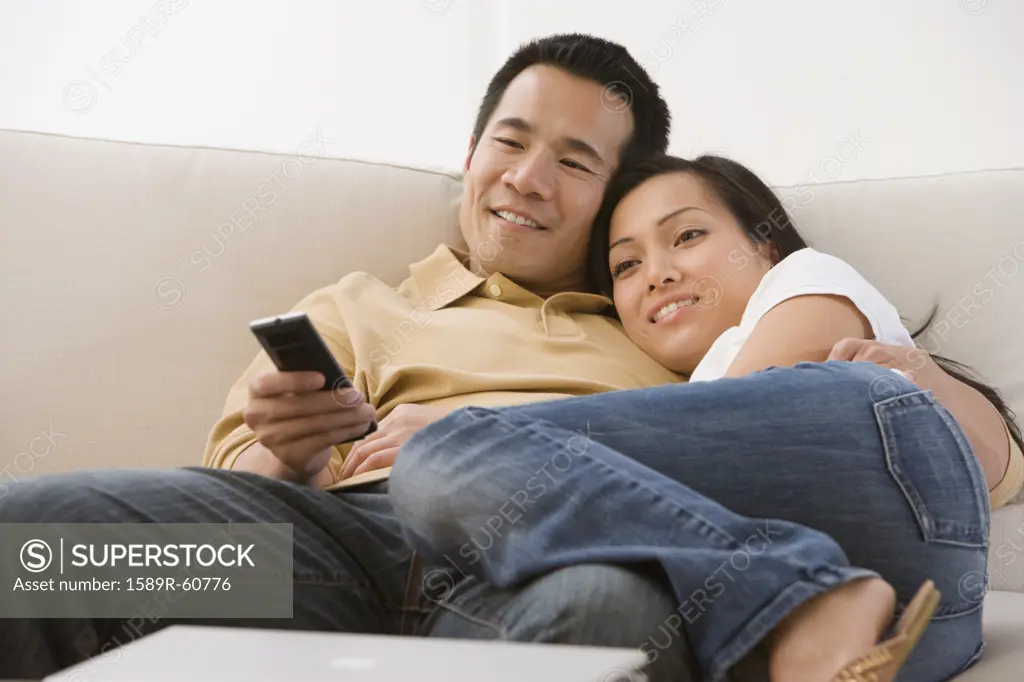 Asian couple watching television