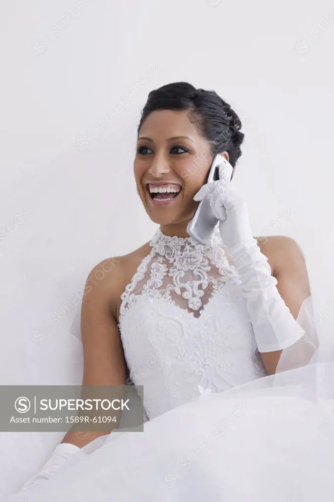 Hispanic bride talking on cell phone