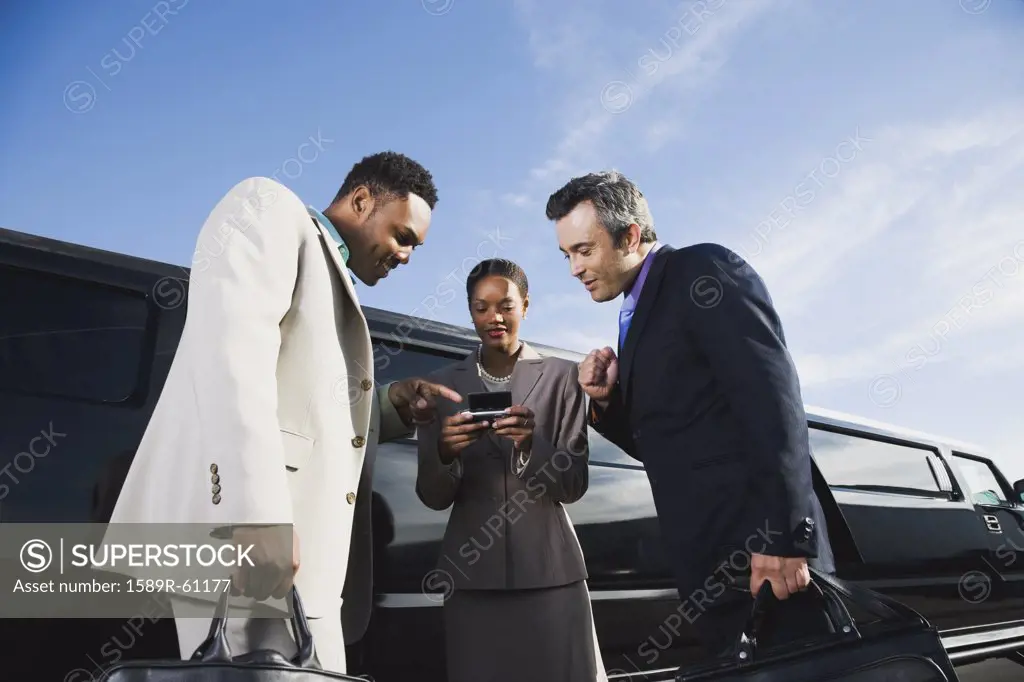Multi-ethnic businesspeople looking at cell phone