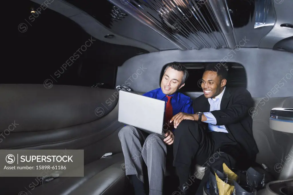 Multi-ethnic businessmen looking at laptop