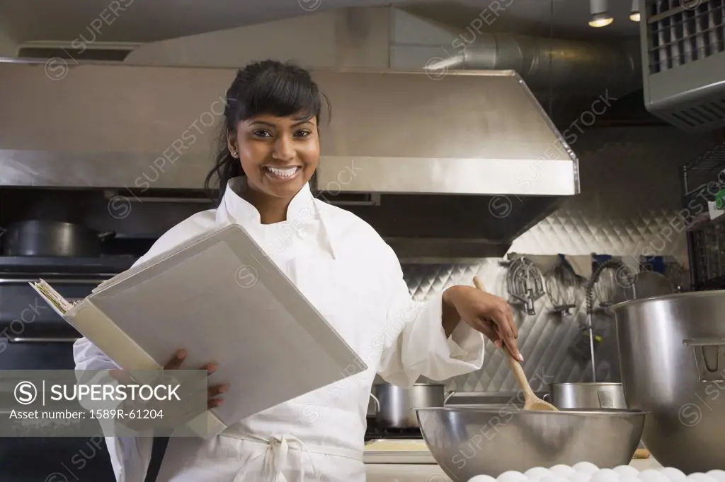 Mixed Race female baker mixing batter
