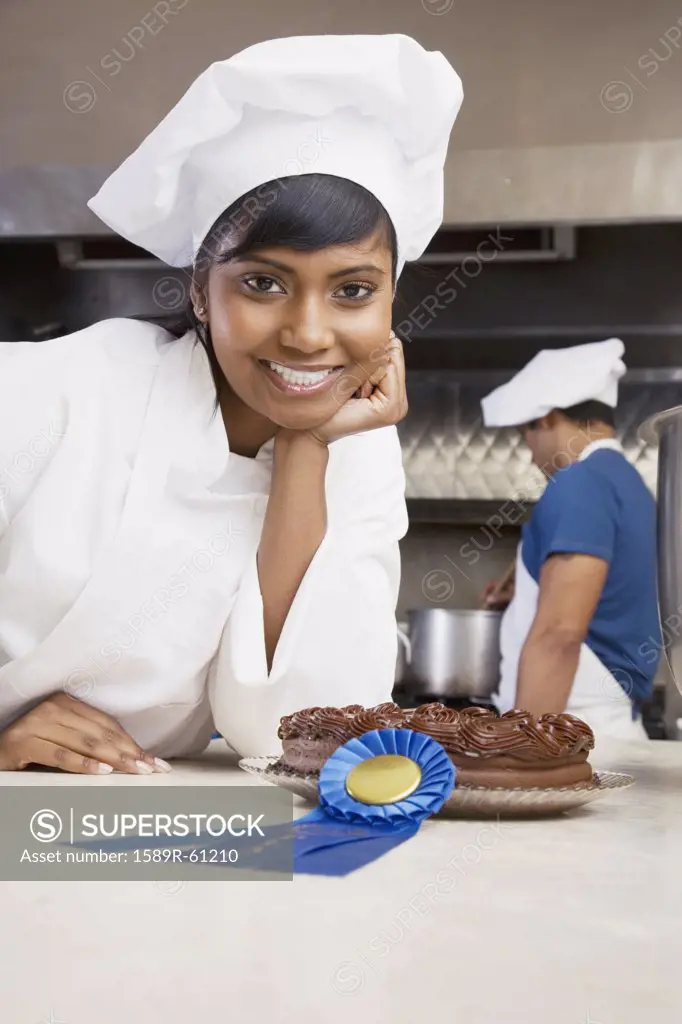 Mixed Race female pastry chef with blue ribbon and cake