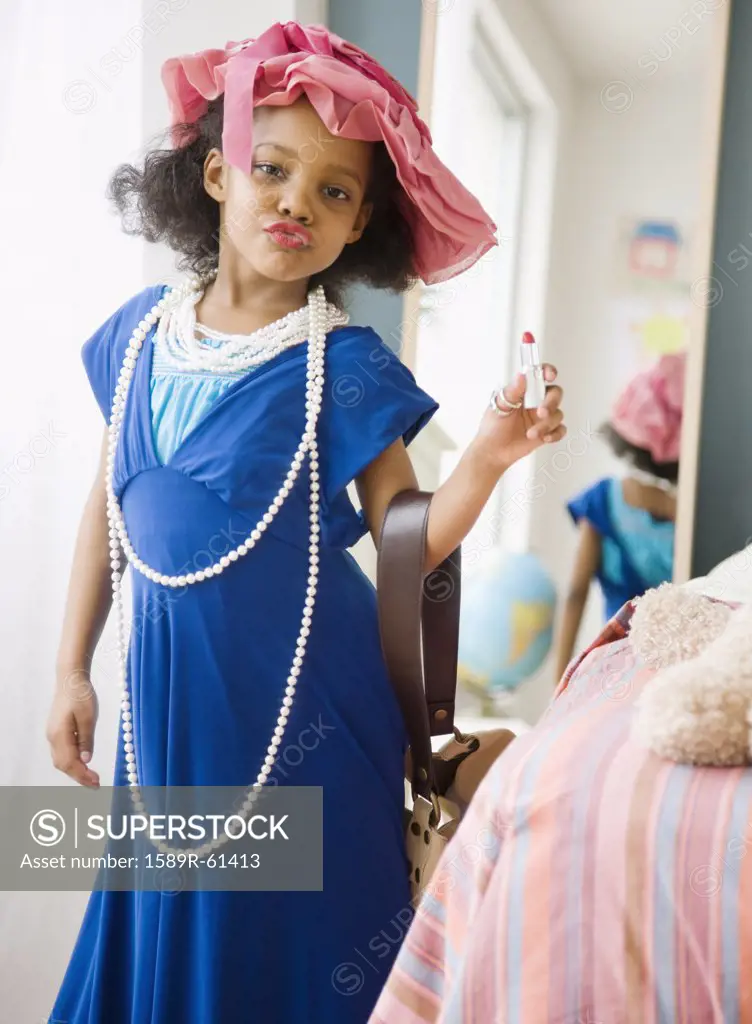 Mixed race girl playing dress-up in mothers clothes