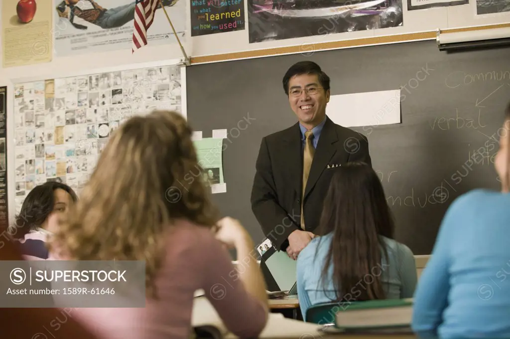 Asian teacher talking to students in classroom