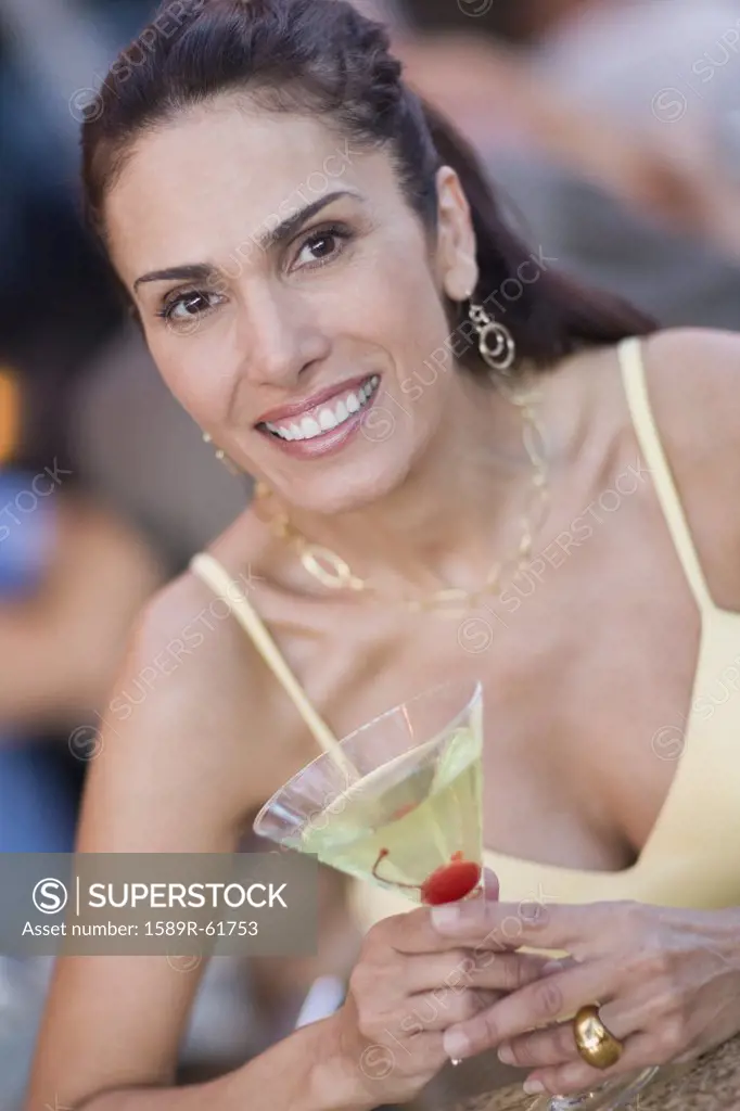 Mixed race woman holding martini glass