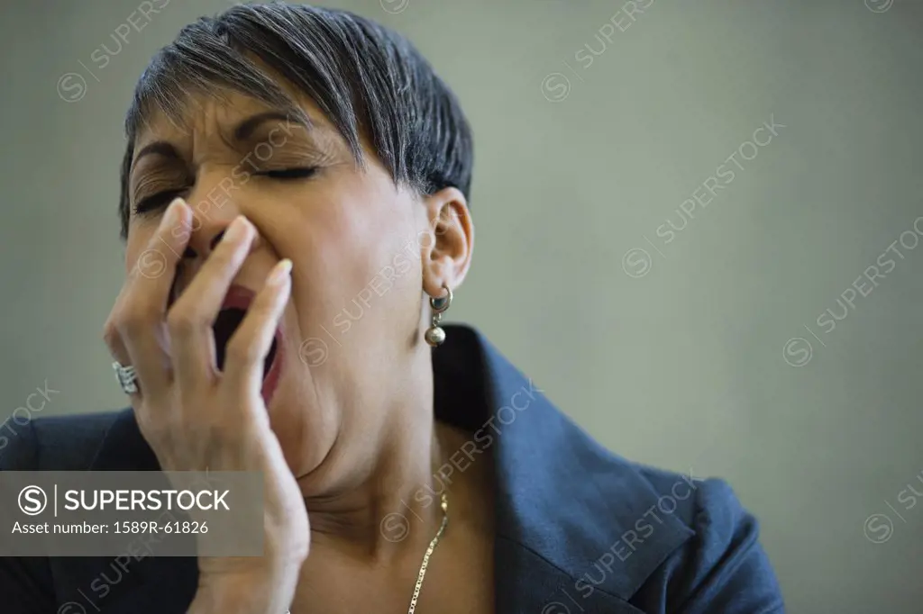 African businesswoman yawning