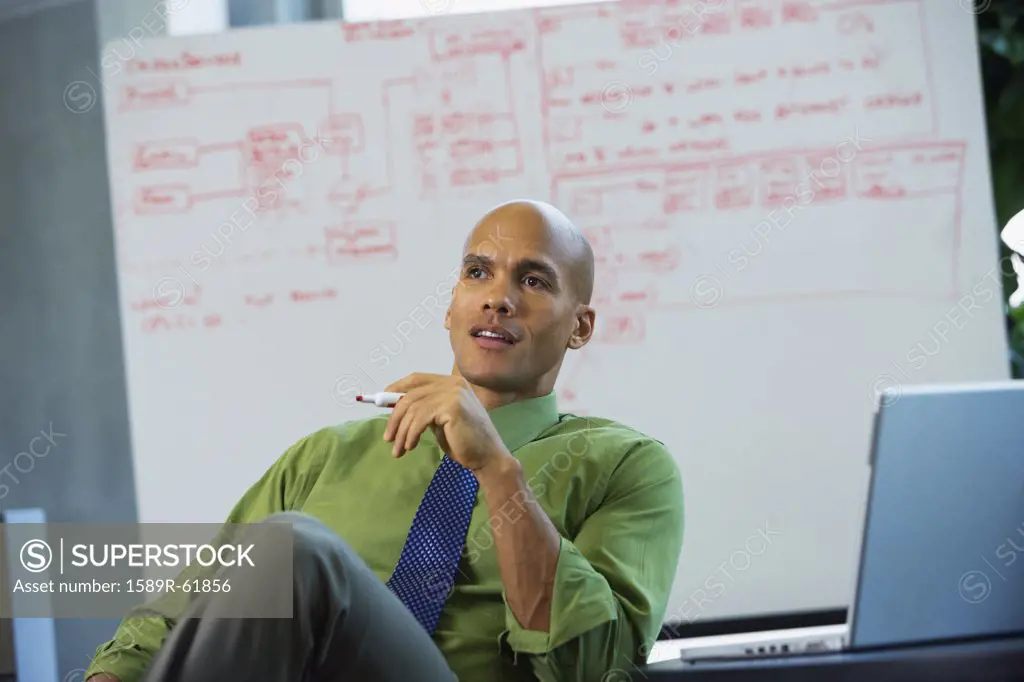 Mixed race businessman sitting in office