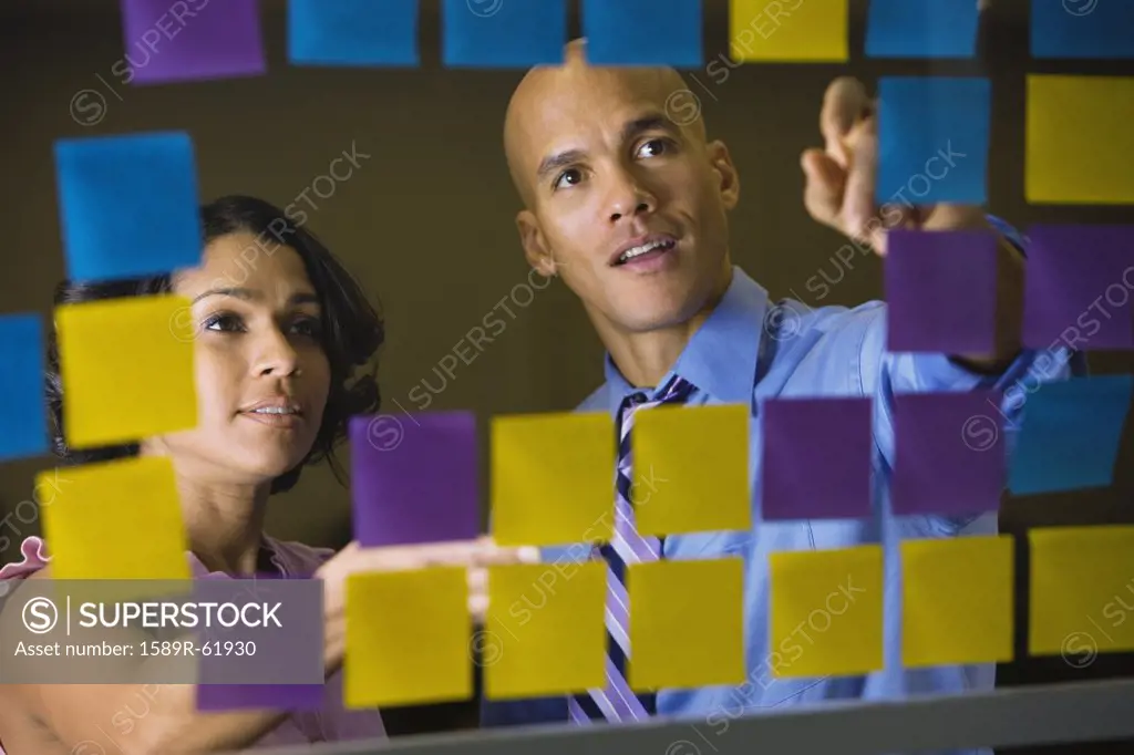 Multi-ethnic business people reviewing sticky notes