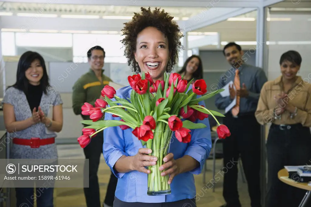 African businesswoman holding bouquet of flowers