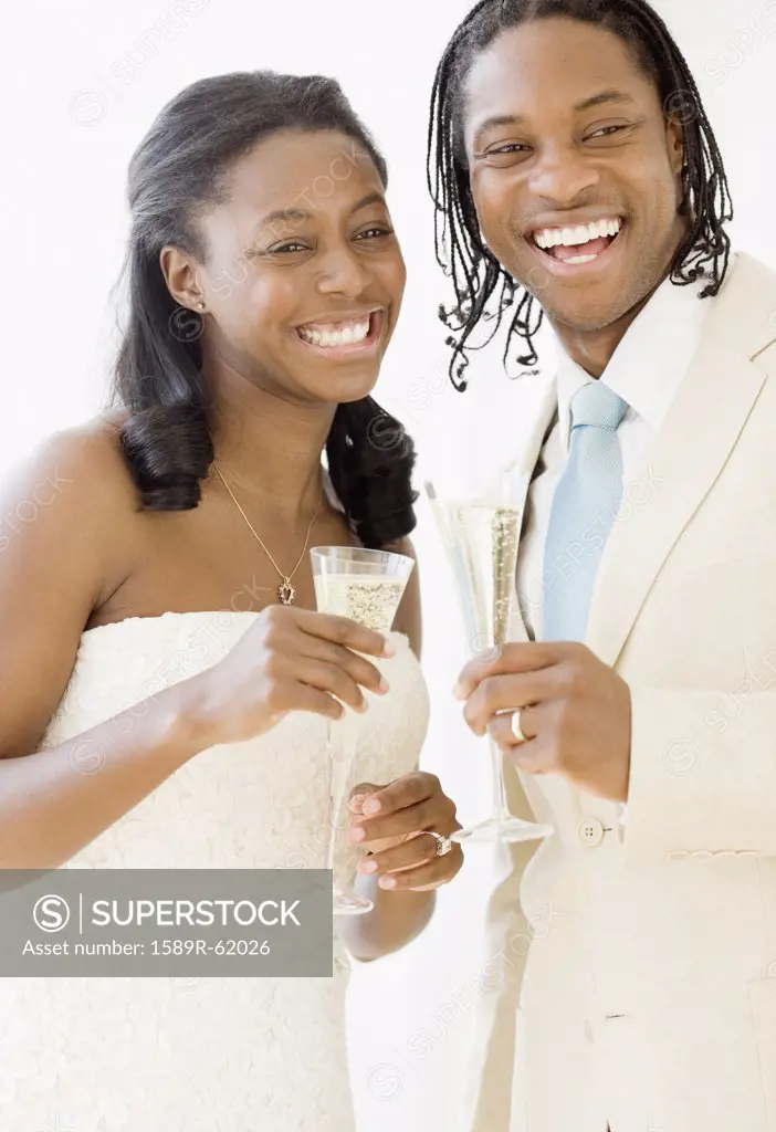 African bride and groom holding champagne flutes