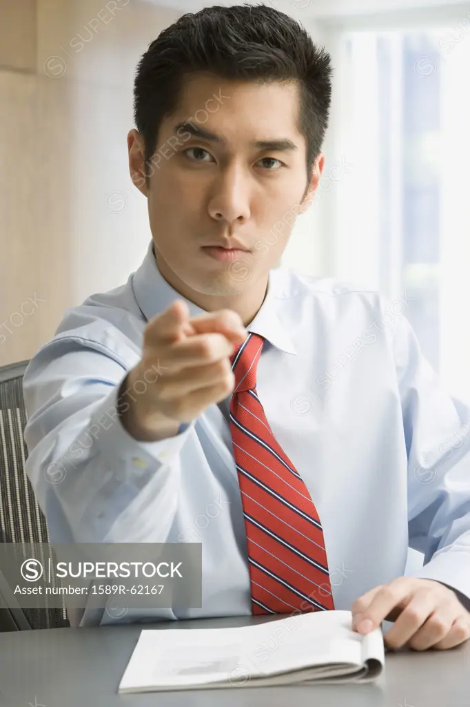 Korean businessman pointing and looking serious