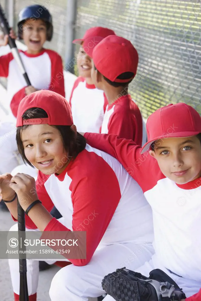 Multi-ethnic boys in baseball uniforms in dugout
