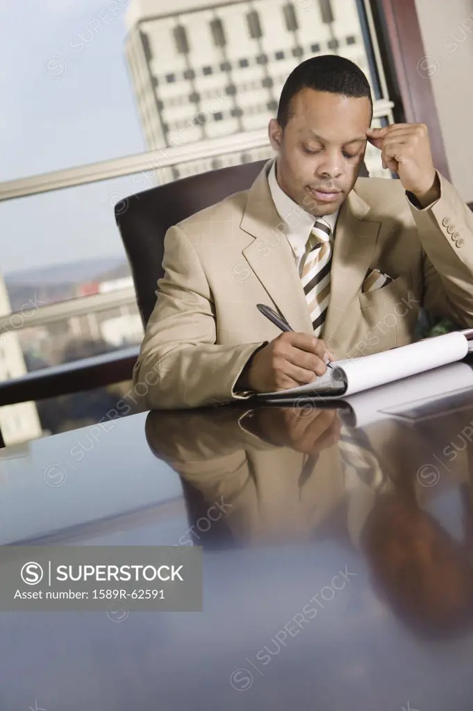 African businessman writing on notepad